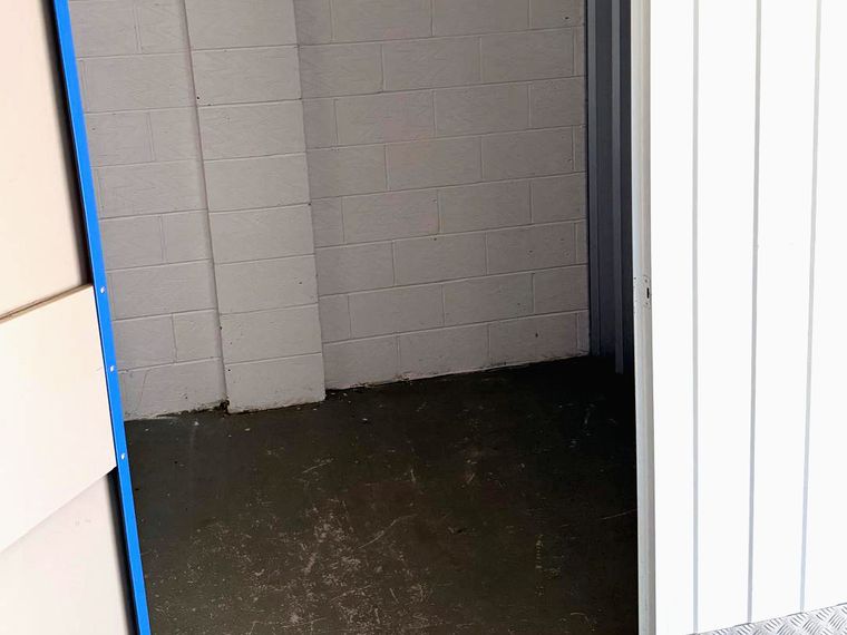 Inside an empty storage unit, showing the clean floor and painted walls